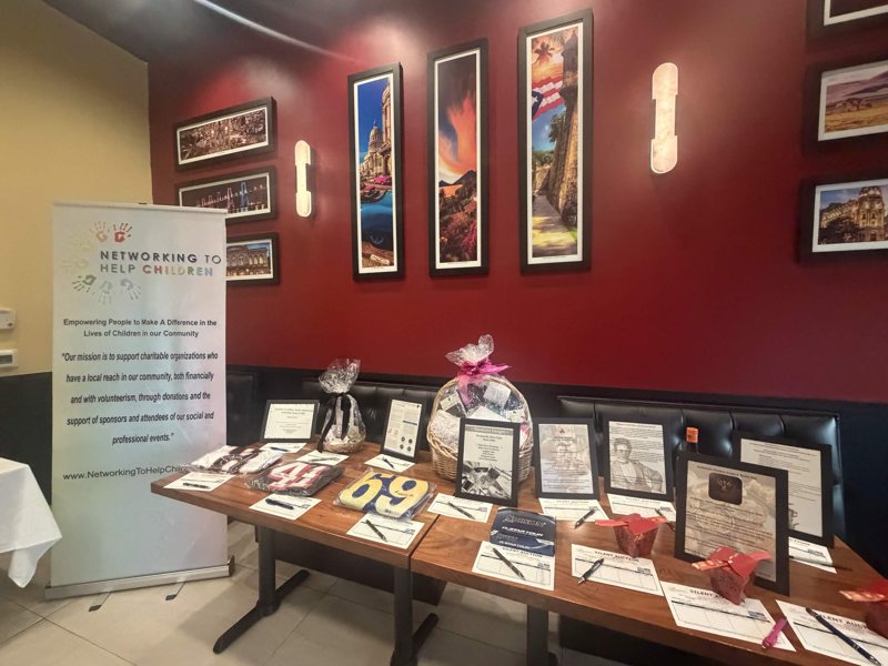 The Networking To Help Children banner and silent-auction table.